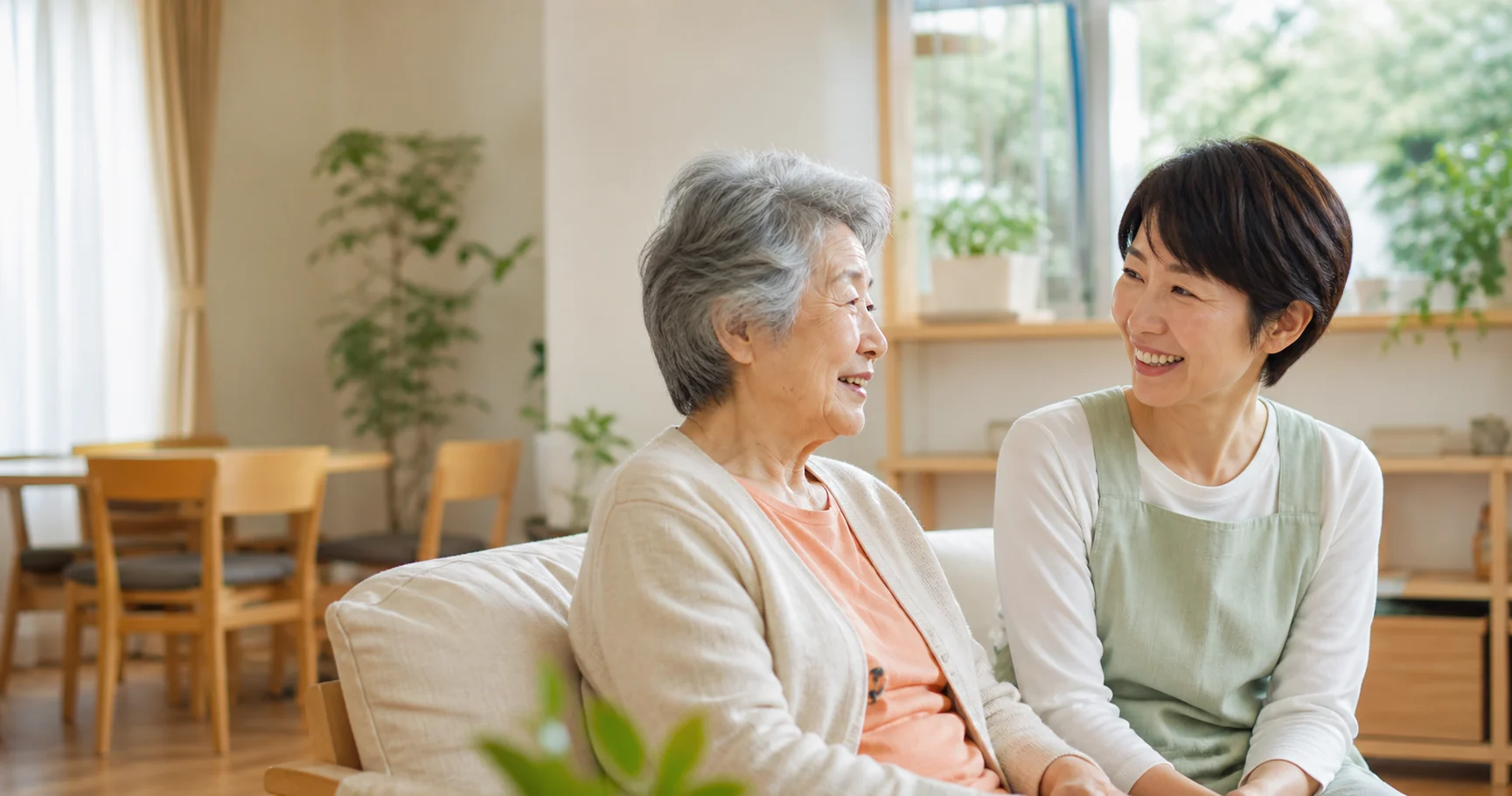 明るいリビングで穏やかに会話をする利用者と介護スタッフ